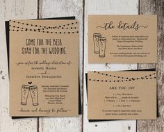 the wedding stationery is laid out on a wooden surface with string lights strung across it