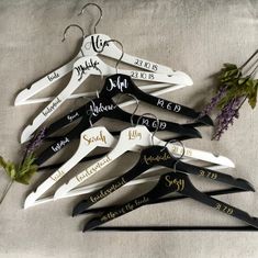 a bunch of clothes hangers with names on them and some flowers in the middle