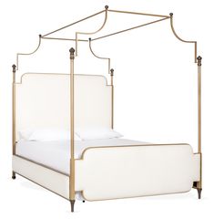 a white bed with a metal frame and headboard