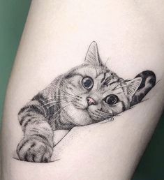 a small cat tattoo on the thigh