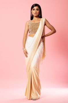 Ivory, gold ombre pre-stitched saree. Paired with sequin embroidered sleeveless padded blouse.
Components: 2
Pattern: Embroidery
Type Of Work: Sequin
Neckline: Scoop neck
Sleeve Type: Sleeveless
Fabric: Crepe Silk
Color: Ivory,Gold
Other Details: 
Back deep U neck
Attached lining
Occasion: Destination Wedding - Aza Fashions Golden Sequin Saree, Golden Ombre, Royal Blue Lehenga, Stitched Saree, Raw Silk Lehenga, Sequin Saree, Yellow Lehenga, Ivory Blouse, Green Lehenga