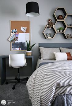 a bed room with a neatly made bed next to a desk and shelves on the wall