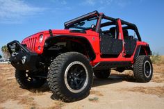 a red jeep is parked in the desert