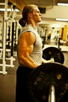 a man holding a barbell in a gym