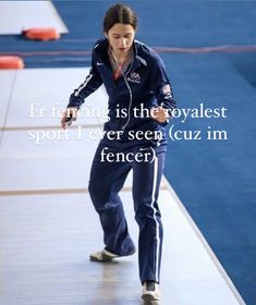 a woman in blue tracksuits and headphones is on the floor with her hands behind her back