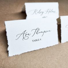 three place cards with calligraphy on them