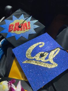 a blue graduation cap with gold glitter on it and the word baum spelled out