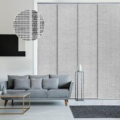 a living room with grey blinds and furniture