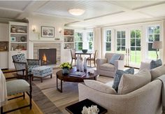 a living room filled with furniture and a fire place in the middle of a room