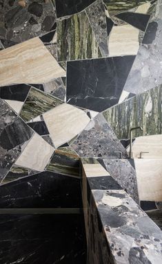 a black and white marble wall with different shapes on it's sides, including the top part of a bench