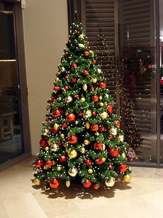 a decorated christmas tree sitting in front of a window