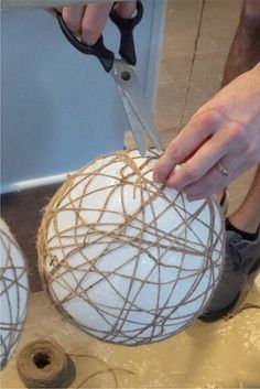 a person cutting rope on top of a white ball