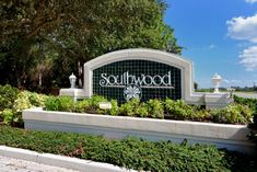 the entrance sign to southwood is surrounded by greenery and bushes on either side