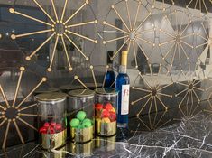 some bottles and cans are sitting on a counter with gold lines around them, along with other items