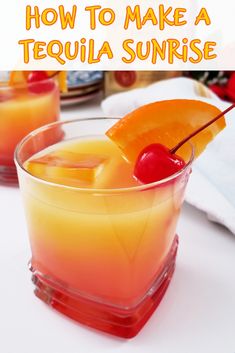 two glasses filled with orange and red drinks on top of a white table next to fruit