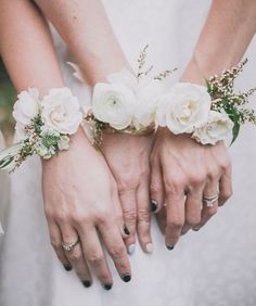 two brides holding hands with white flowers on them