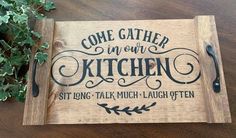 a wooden sign that says, come gather in our kitchen sit long talk much laugh often