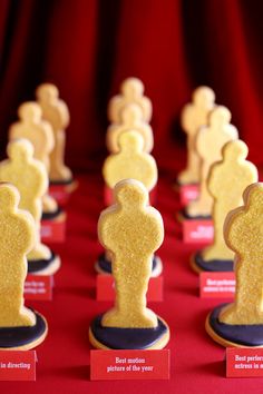 rows of cookies shaped like people on red table cloth