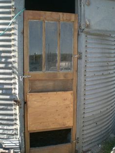 a wooden door is open in front of a metal building