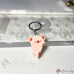 a pink pig keychain sitting on top of a table