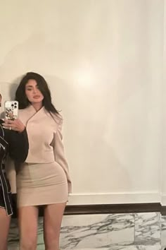 a man and woman taking a selfie in front of a mirror with their cell phones