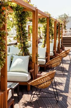 an outdoor seating area with wicker chairs and white cushions