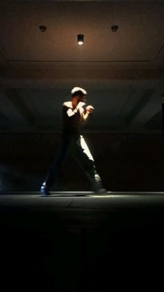 a man is dancing in the dark on stage