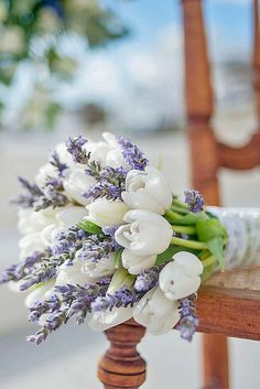 a bouquet of flowers sitting on top of a wooden chair