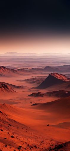 the desert is covered in red sand and some mountains are seen at sunset or dawn