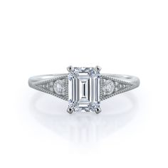 an emerald cut diamond engagement ring with two side stones