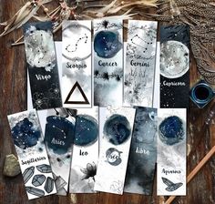 some cards with zodiac signs on them sitting on a wooden table next to other items