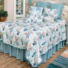 a bed with blue and white bedspread in a room