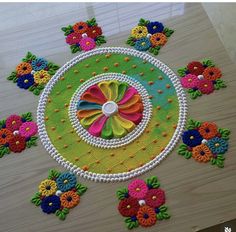 an artistically decorated table top with flowers and circles in the center, surrounded by beads