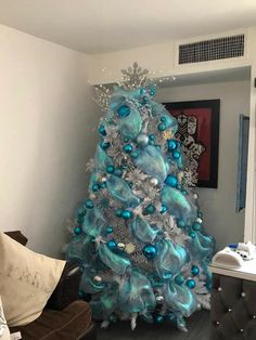 a blue and silver christmas tree in a living room