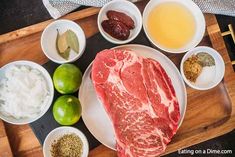 raw meat and other ingredients on a cutting board next to limes, olives, sour cream