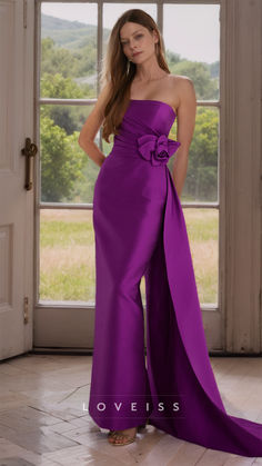 a woman in a long purple dress standing by a window with her hands on her hips