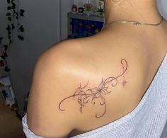 the back of a woman's shoulder with a flower tattoo on her left shoulder