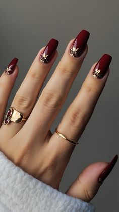 Achieve classy burgundy nails with these dark red design ideas for a polished French tip look From classic black to short and chic explore artful nail designs including chrome and acrylic short nails Get inspired by these elegant burgundy nail design suggestions for a stylish and sophisticated manicure Burgundy And Gold Nails Short, Red Gel Nails Designs Classy, Deep Red Nails With Gold, Classy Red Nails Design, Fall Red Nails Designs, Burgundy Fall Nails Designs, Red Nail Art Elegant, Nail Art Red And Gold, Dark Red And Gold Nails