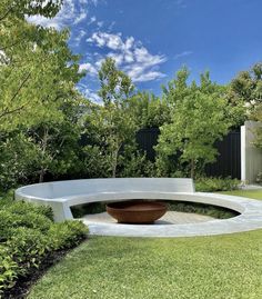 a circular concrete bench in the middle of a garden