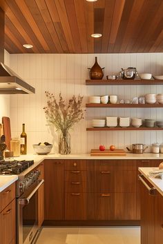 a kitchen filled with lots of wooden cabinets and counter top space next to a stove top oven