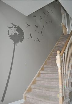 a staircase leading up to a wall with a dandelion stencil on it