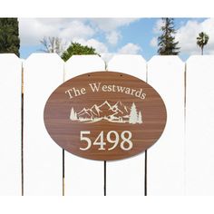 a wooden sign that says the westwards 5498 in front of a white picket fence