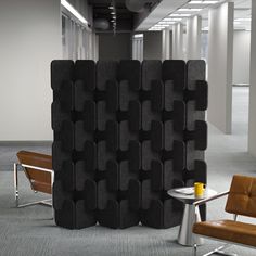 a room divider in the middle of an office with two chairs and a table