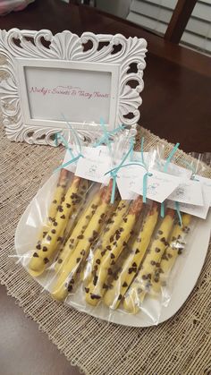 bananas wrapped in cellophane with chocolate chips on them sitting on a white plate