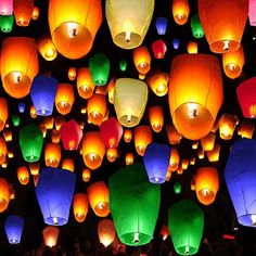 many colorful lanterns floating in the air