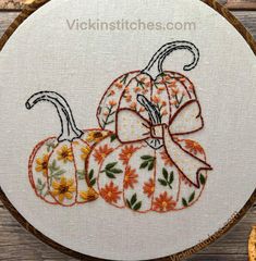 a white hoop with orange and yellow pumpkins on it