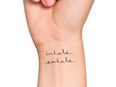 a woman's arm with the words inside exhale written on it, in black ink