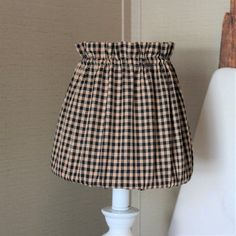 a lamp with a black and white checkered shade sitting on top of a table