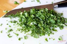 chopped parsley on a cutting board next to a knife