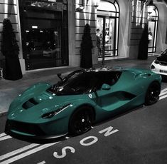 two green sports cars are parked on the street